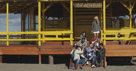 Image showing Group of friends having fun on autumn day at beach