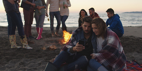 Image showing Couple enjoying bonfire with friends on beach