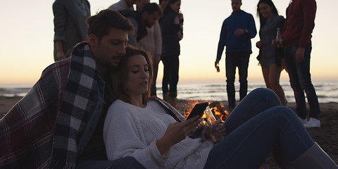 Image showing Couple enjoying bonfire with friends on beach