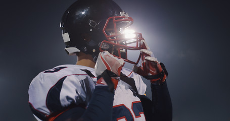 Image showing American Football Player Putting On Helmet on large stadium with