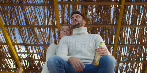 Image showing Couple drinking beer together at the beach