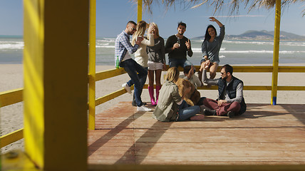 Image showing Group of friends having fun on autumn day at beach