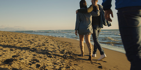 Image showing Group of friends having fun on beach during autumn day