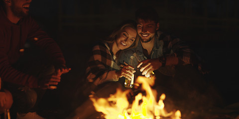 Image showing Couple enjoying with friends at night on the beach