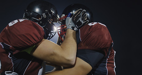 Image showing American football players knocking with helmets and having fun