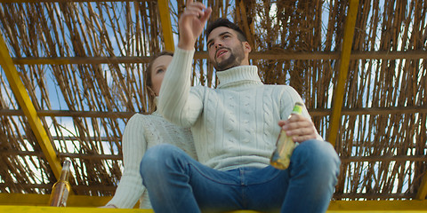 Image showing Couple drinking beer together at the beach