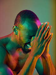 Image showing Close up portrait of a young naked african man crying at camera indoors