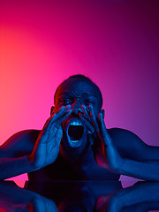 Image showing Close up portrait of a young naked african man screaming at camera indoors