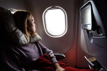 Image showing Tired blonde casual caucasian lady sleepin on seat while traveling by airplane. Commercial transportation by planes.