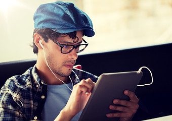 Image showing close up of man with tablet pc and earphones