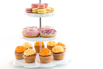 Image showing glazed donuts, cupcakes and macarons on stand