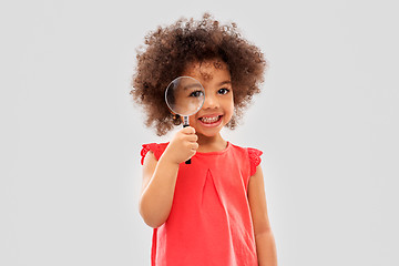 Image showing african girl looking through magnifying glass