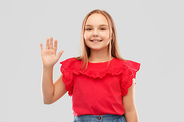 Image showing beautiful smiling girl in red shirt waving hand