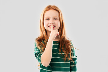 Image showing smiling red haired girl making shush gesture