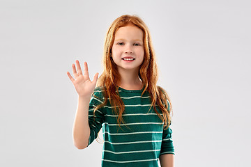 Image showing smiling red haired girl waving hand