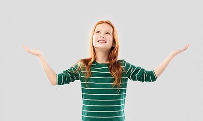 Image showing happy grateful red haired girl looking up above