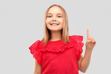 Image showing smiling girl in red shirt pointing finger up