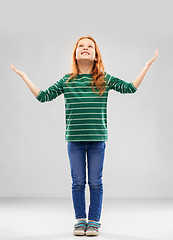 Image showing happy grateful red haired girl looking up above