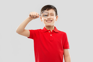 Image showing smiling boy looking through magnifying glass
