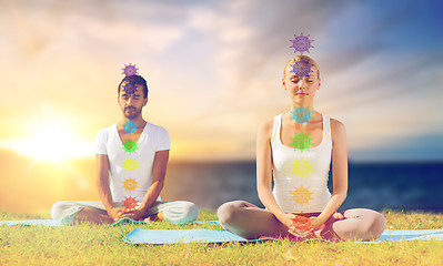 Image showing couple doing yoga in lotus pose with seven chakras