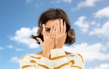 Image showing young woman looking by one eye through her fingers