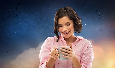 Image showing happy young woman in pajama with mug of coffee