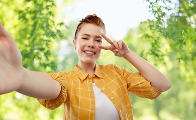 Image showing redhead teenage girl taking selfie making peace