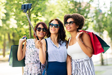 Image showing women with shopping bags taking selfie outdoors