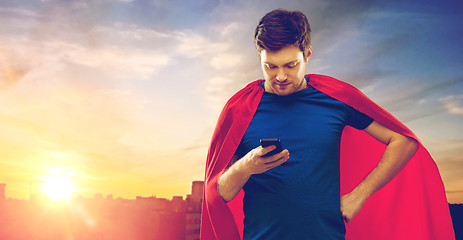 Image showing man in red superhero cape using smartphone