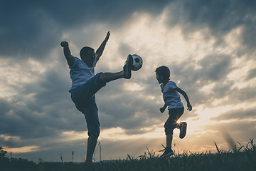 Image showing Father and young little boy playing in the field  with soccer ba
