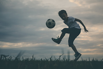 Image showing Young little boy playing in the field  with soccer ball.