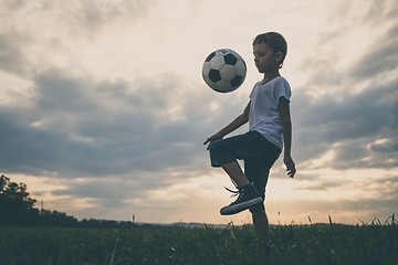 Image showing Young little boy playing in the field  with soccer ball.