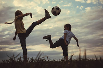 Image showing Happy young little boy and girl playing in the field  with socce