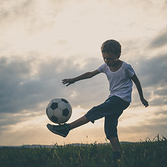 Image showing Young little boy playing in the field  with soccer ball.