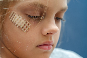 Image showing On the girl\'s face is glued Band-Aid, close-up