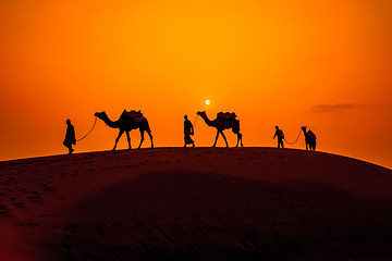 Image showing Cameleers, camel Drivers at sunset. Thar desert on sunset Jaisal