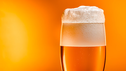 Image showing Lager beer settles in the glass with a white cap of foam