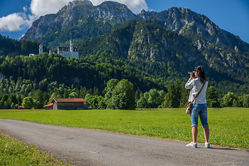 Image showing Female tourist taking photos Neuschwanstein Castle Bavarian Alps