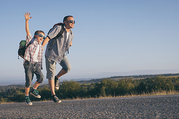 Image showing Father and  son playing on the road at the day time.