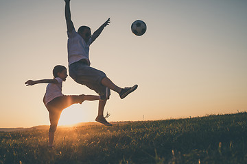 Image showing Father and young little boy playing in the field  with soccer ba