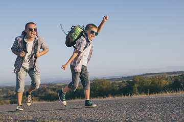 Image showing Father and  son playing on the road at the day time.