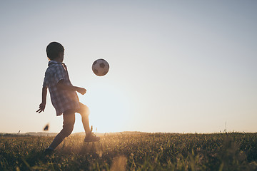 Image showing Young little boy playing in the field  with soccer ball.