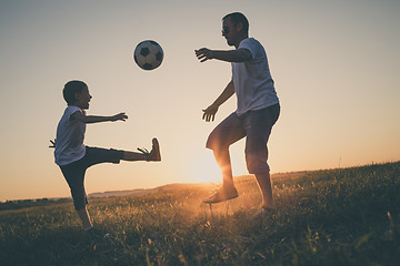 Image showing Father and young little boy playing in the field  with soccer ba