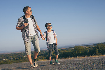 Image showing Father and  son playing on the road at the day time.