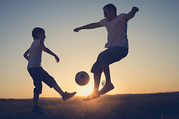 Image showing Father and young little boy playing in the field  with soccer ba