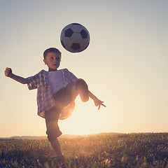 Image showing Young little boy playing in the field  with soccer ball.