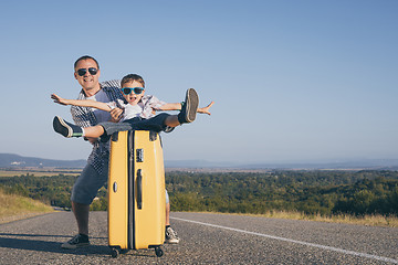 Image showing Father and  son playing on the road at the day time.