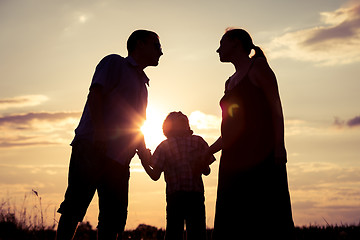 Image showing Happy family standing in the park at the sunset time.