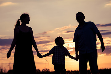 Image showing Happy family standing in the park at the sunset time.