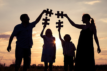 Image showing Happy family standing in the park at the sunset time.